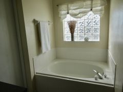 Master En Suite with large garden bath and walk in shower, vanity unit and separate toilet cubicle. Access directly to the patio and pool area.